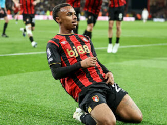 Footballeur célébrant un but en glissant sur la pelouse
