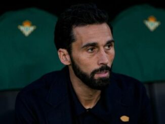 Homme barbu assis sur un banc de stade