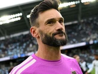 Footballeur barbu en maillot rose au stade
