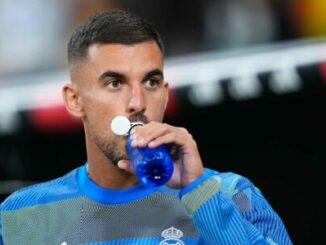 Footballeur buvant une boisson énergétique bleue