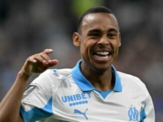 Footballeur souriant en maillot blanc et bleu
