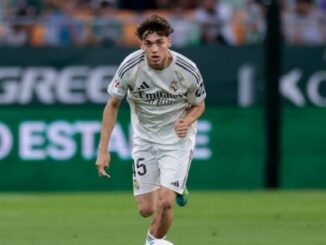 Footballeur en maillot blanc courant sur le terrain
