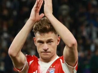 Footballeur en maillot rouge applaudissant au stade
