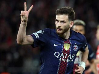 Footballeur du PSG faisant signe de victoire