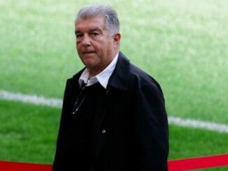 Homme debout au bord d’un terrain de football