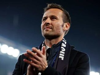 Homme applaudissant sous les projecteurs d’un stade
