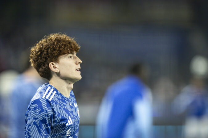 Jeune footballeur en maillot bleu sur le terrain