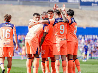 Joueurs de football en orange célébrant ensemble