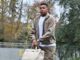 Homme tenant un sac beige en extérieur