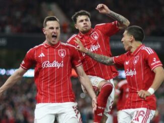 Joueurs de football en rouge célébrant un but