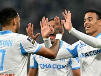 Footballeurs en maillot blanc se félicitant sur le terrain