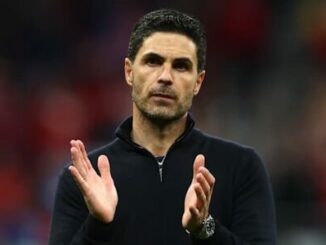 Homme en noir applaudissant dans un stade