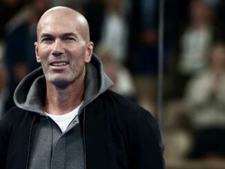 Homme chauve souriant dans un stade