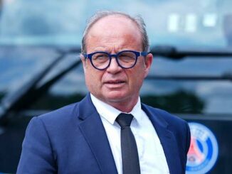 Homme en costume devant véhicule au logo bleu