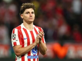 Footballeur en maillot rouge et blanc applaudissant