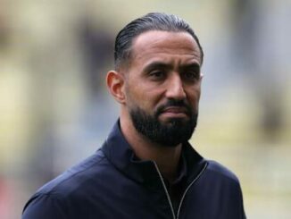Homme barbu en veste noire, arrière-plan flou