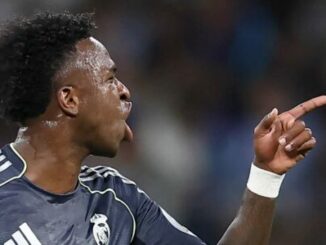 Footballeur en maillot sombre pointant du doigt