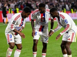 Trois joueurs de football célèbrent sur le terrain