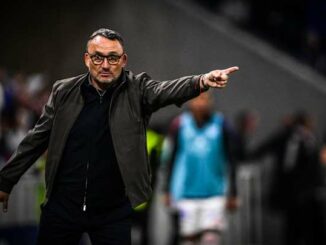 Entraîneur de football pointant sur le terrain