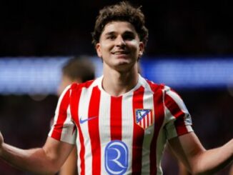 Footballeur en maillot rouge et blanc souriant