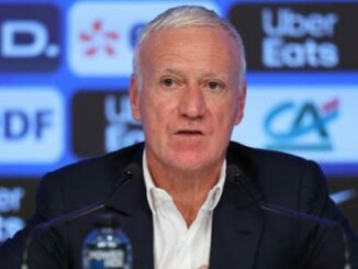 Homme en conférence de presse devant logos sponsors