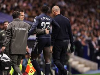 Joueur de football blessé aidé hors du terrain