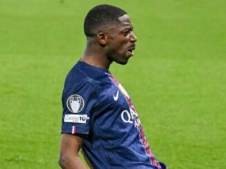 Footballeur en maillot bleu sur terrain vert