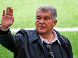 Homme levant la main sur fond de stade
