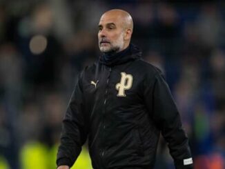 Homme en veste noire sur terrain de football