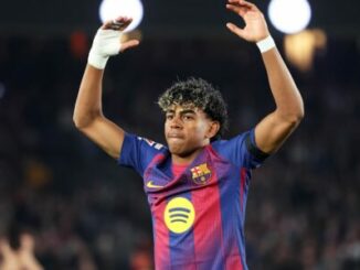 Joueur de football levant les bras en stade