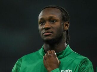 Joueur de football en maillot vert regardant devant lui