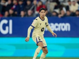 Joueur de football en maillot beige sur le terrain