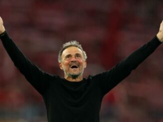 Homme levant les bras dans un stade