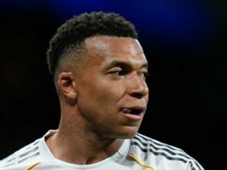 Joueur de football en maillot blanc regardant côté