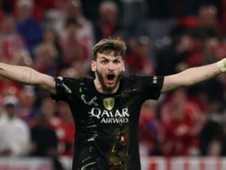 Footballeur célébrant bras écartés dans un stade
