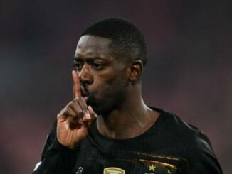 Footballeur en maillot noir faisant silence