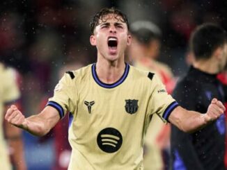 Footballeur célébrant un but sous la pluie