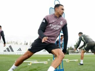 Footballeur s'étirant à l'entraînement sur terrain