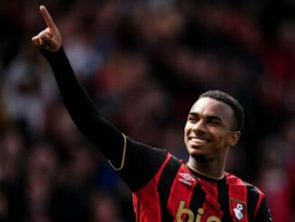 Footballeur en maillot rouge et noir célébrant