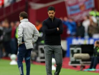 Entraîneur pensif au bord d’un terrain de football