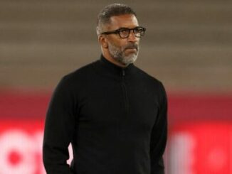 Homme en pull noir dans un stade