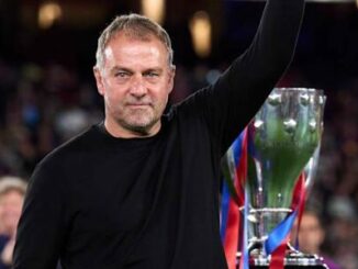 Homme levant le bras près d'un trophée