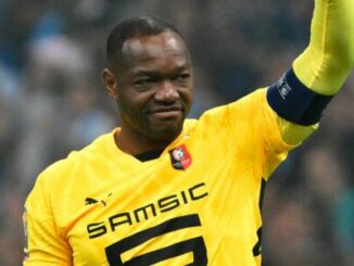 Footballeur en maillot jaune levant le bras
