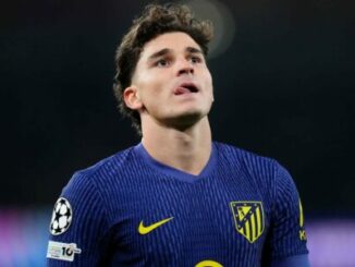 Footballeur en maillot bleu regardant vers le ciel