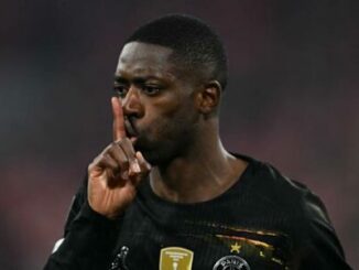 Footballeur en noir faisant geste de silence
