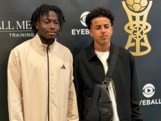 Deux jeunes hommes devant un mur promotionnel sportif