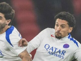 Deux footballeurs en duel sous maillot blanc