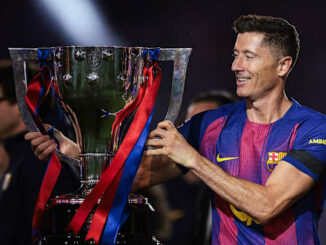 Footballeur tenant un grand trophée aux rubans rouges