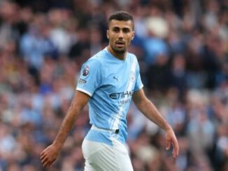 Footballeur en maillot bleu clair sur le terrain