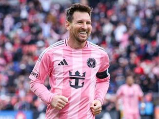 Footballeur en maillot rose souriant sur le terrain